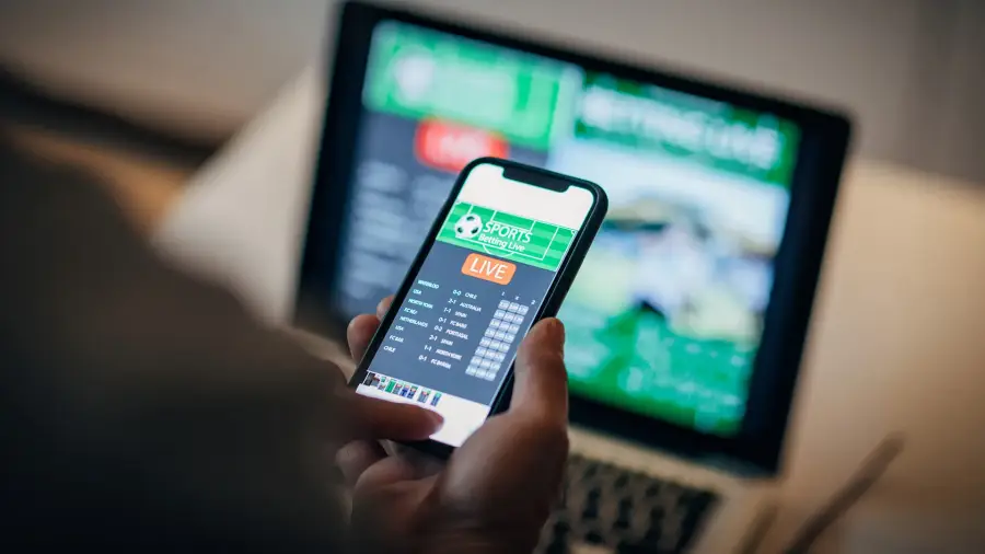 man-using-mobile-app-for-live-betting-and-online-gambling-and-watching-a-sports-match